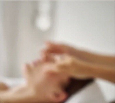 Facial massage treatment in a soft natural light room