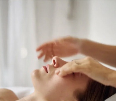 Hands performing a calming facial massage